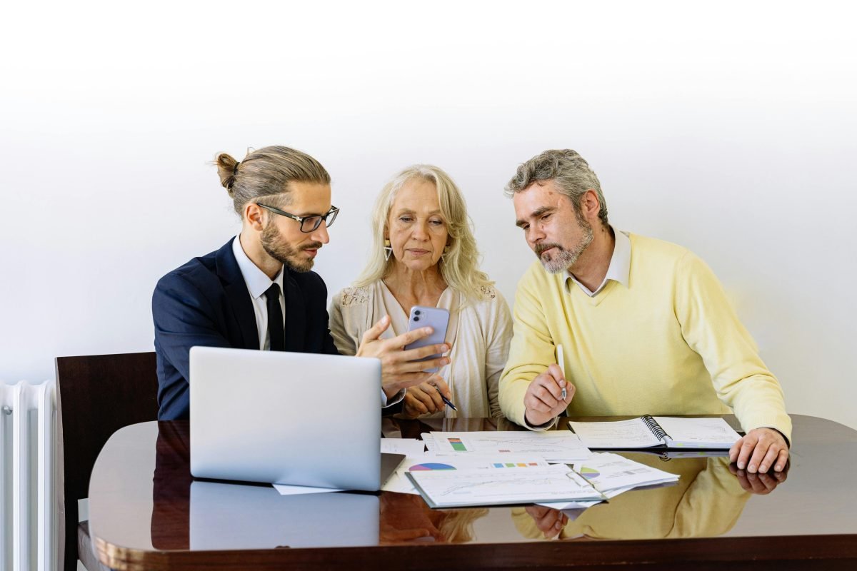 A couple at a table with an advisor discussing online wealth.
