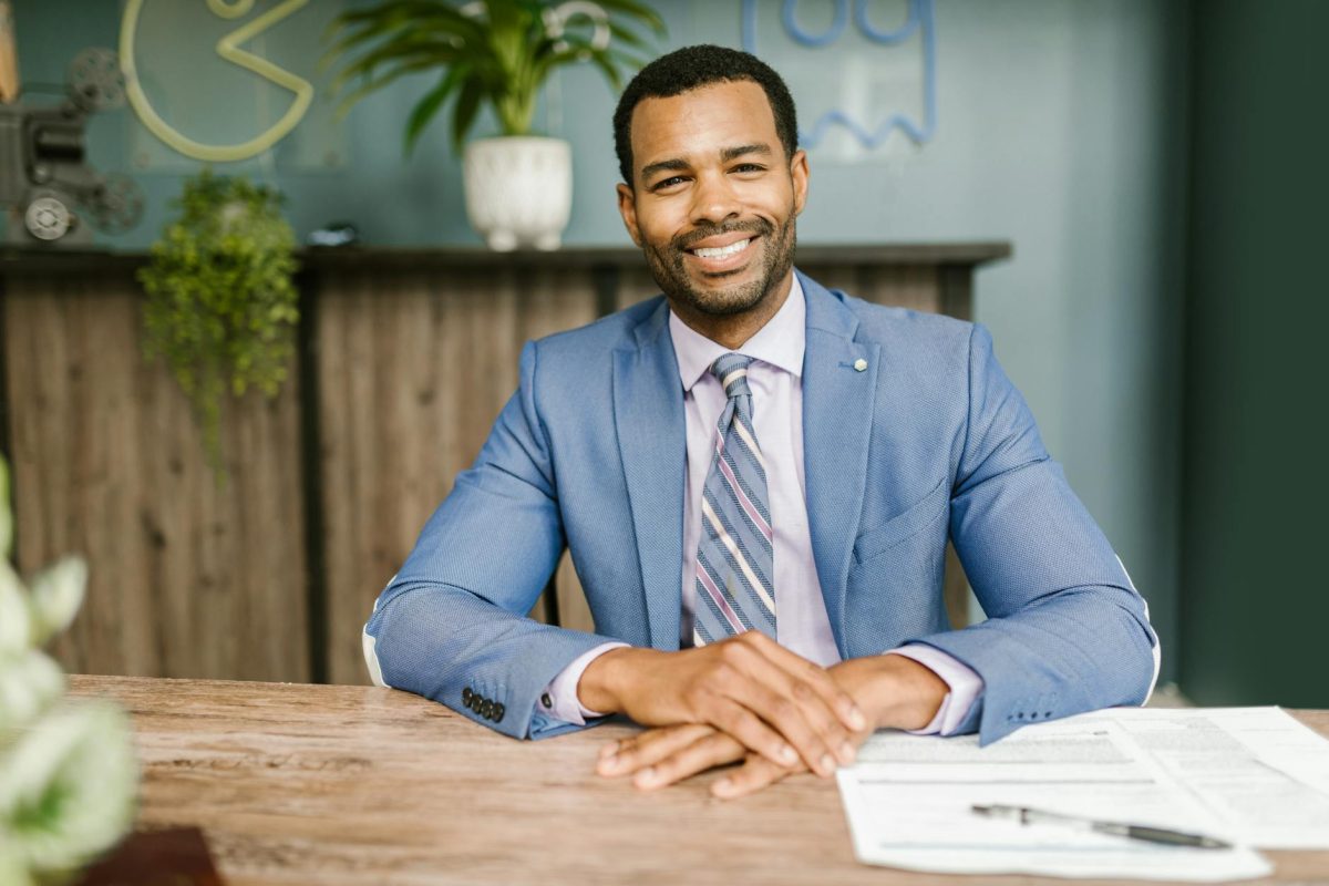 Serial Entrepreneur in blue suit sitting at a desk.
