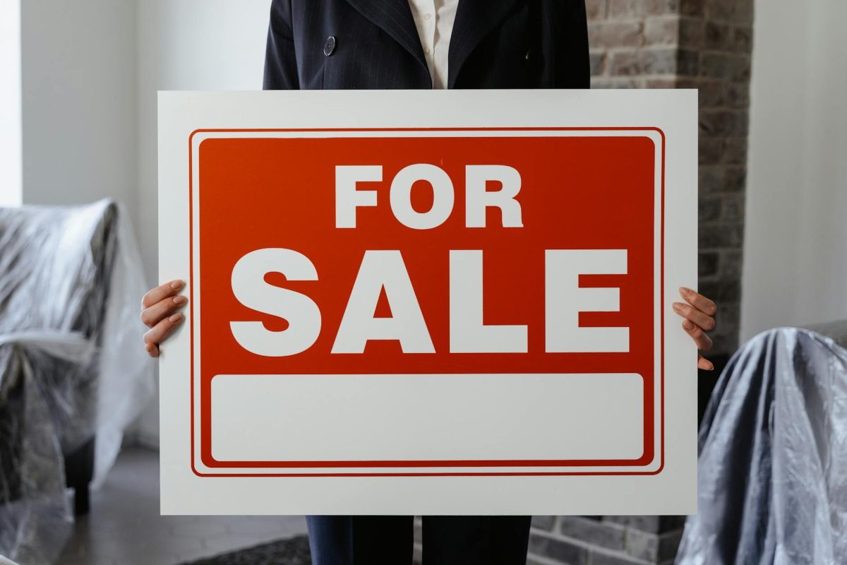 A person holding a for-sale sign for a SaaS business opportunity.