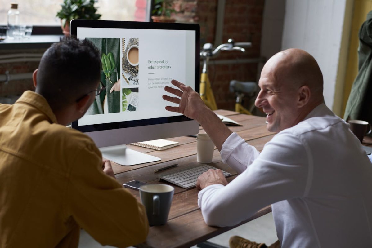Photo of people sitting in front of computers discussing the top ten online businesses buyers are searching for.