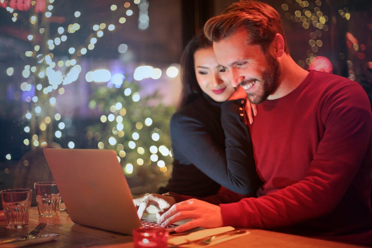 Man and woman sitting in front of laptop.